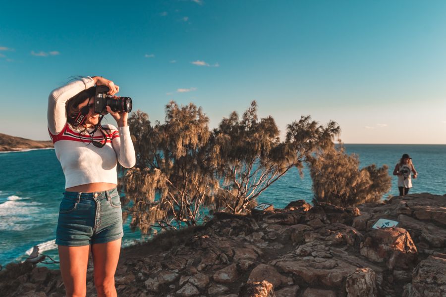 girl on a rocky headland with binoculars