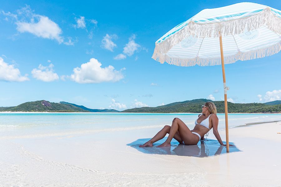 A woman under an umbrella on Whitehaven Beach
