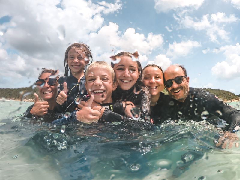 Family in the water with stinger suits, Whitsundays, Australia