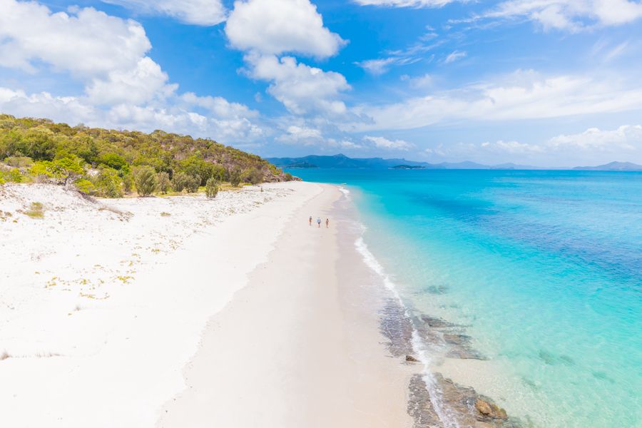 Whitehaven Beach in the Whitsundays Three people walking along Whitehaven Beach in the Whitsundays