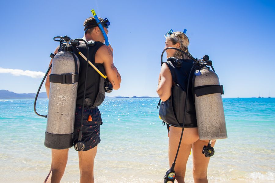 A man and a women in scuba gear learning how to dive