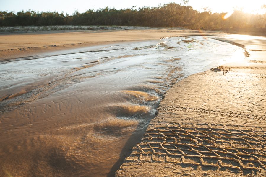 water flowing on the sand on K'gari Eastern Beach