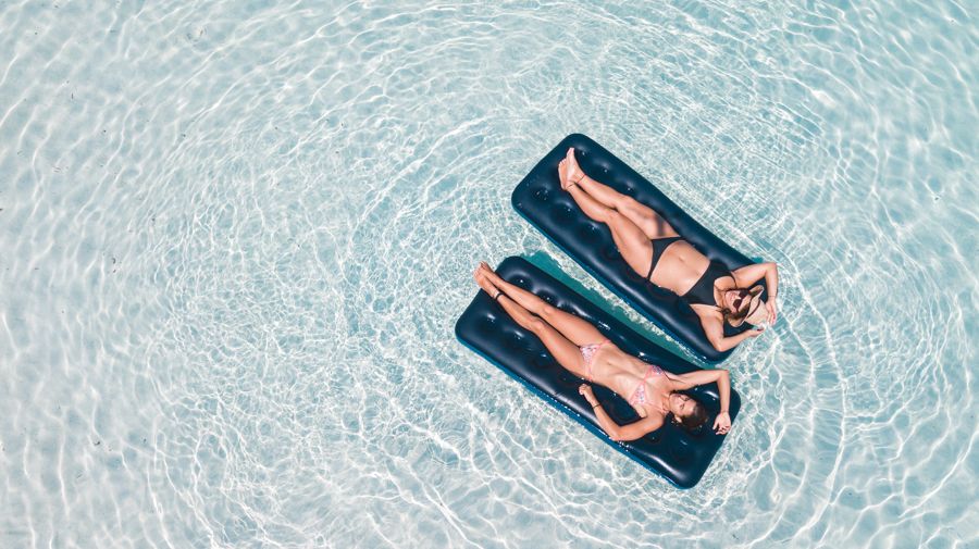 travellers relaxing on floats in lake mckenzie on k'gari