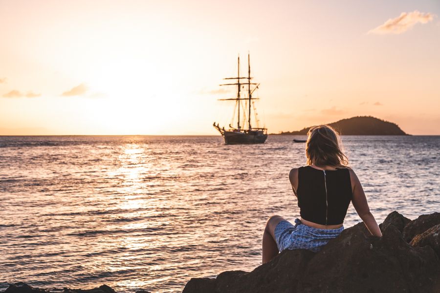 girl looking at a tallship at sunset on Whitehaven Beach