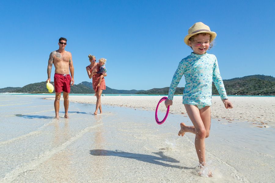 Family walking down Whitehaven Beach