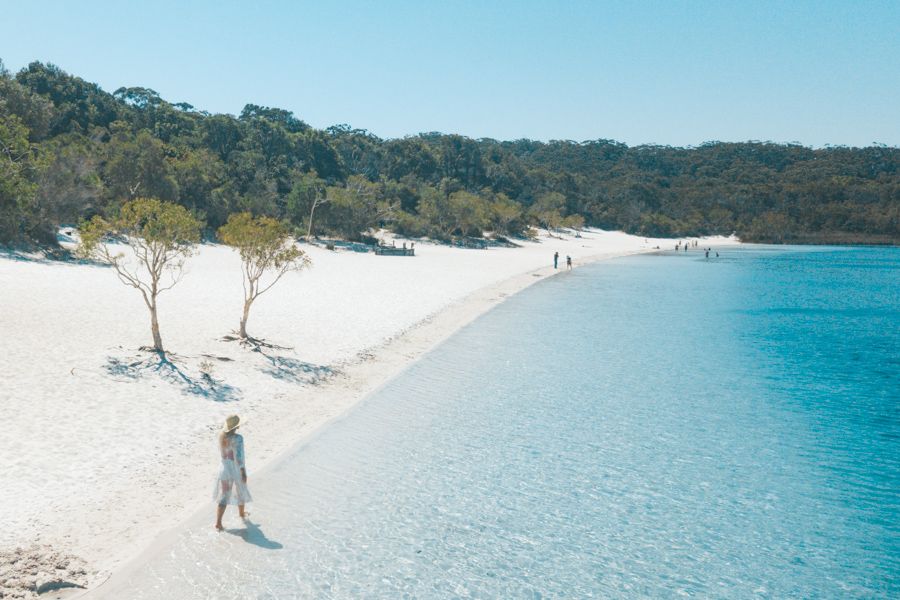 woman walking along the prisitine shoreline of Lake McKenzie