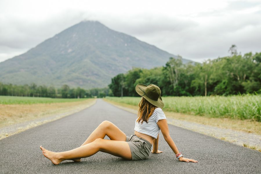 Person sitting on the road with Walshs Pyramid in the distance