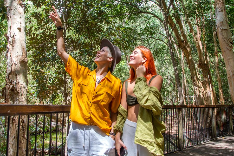 Two girls pointing to the sky in a rainforest