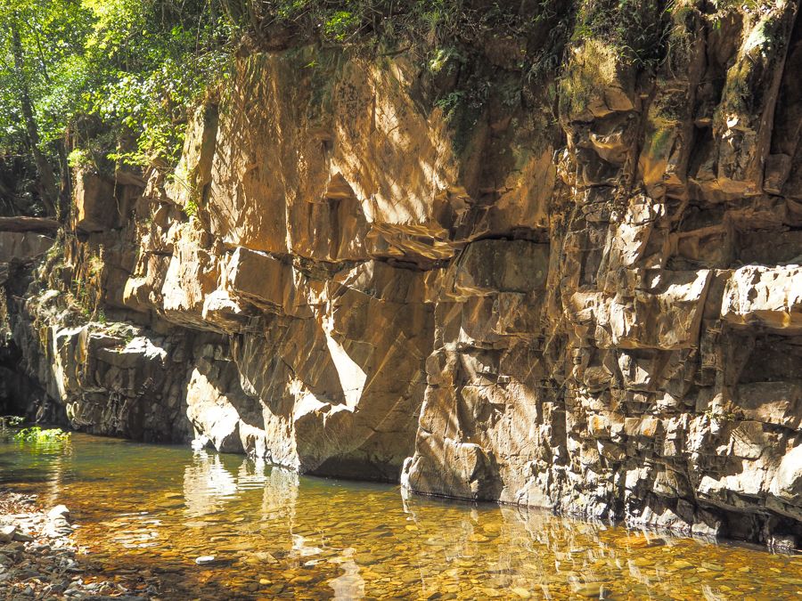 Creek clear water against a wall of rock 