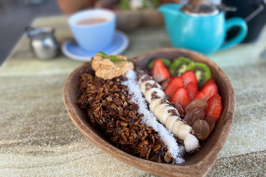 Smoothie bowl in a heart shaped bowl with coffee 