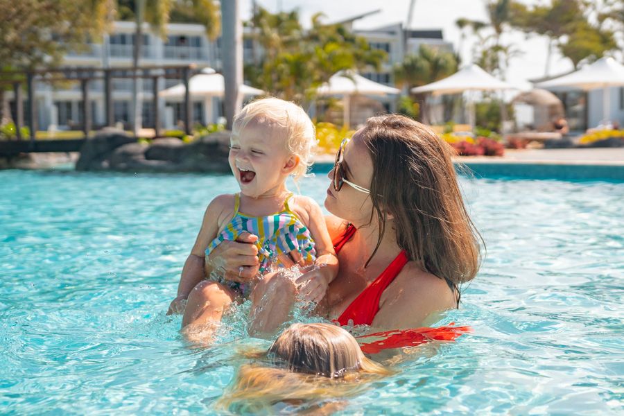 Mother and daughter having fun in a swimming pool, Daydream Island, Whitsundays, Australia