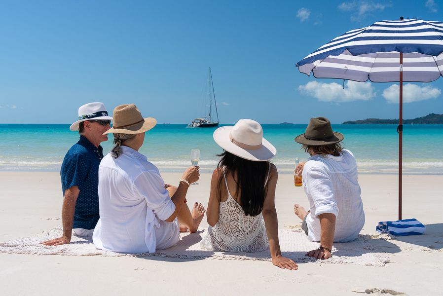 A group of people sitting on the beach