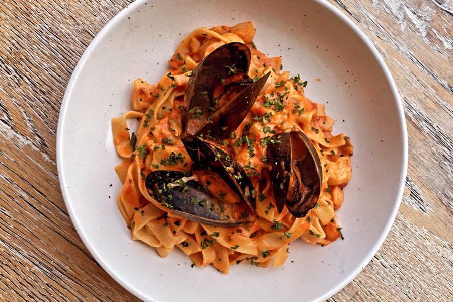 seafood pasta on a timber table at a restaurant in airlie beach