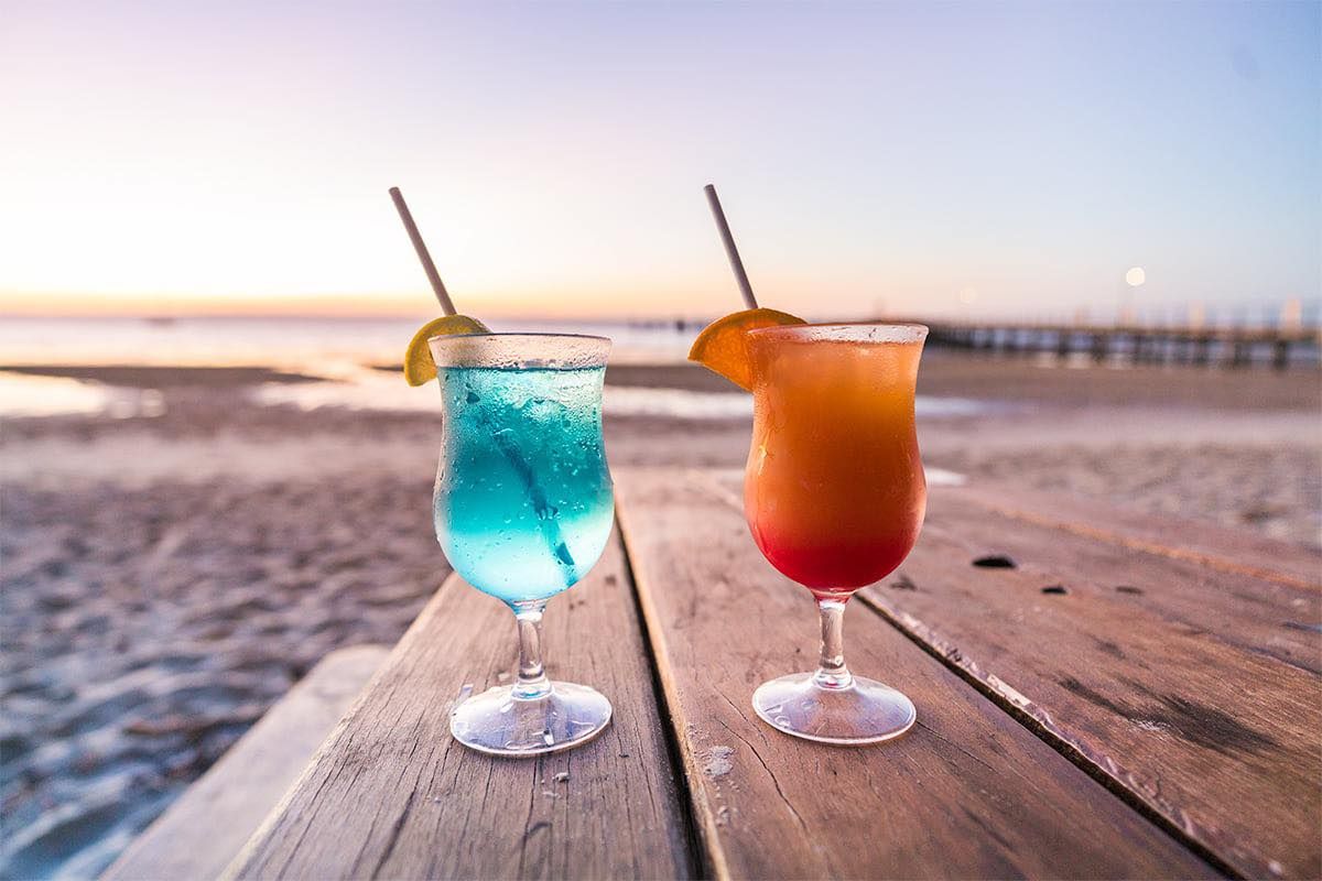 cocktails on a wooden table at sand and wood