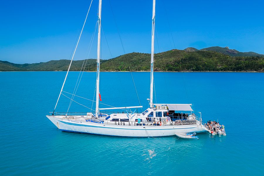 a drone shot of a large white sailing yacht