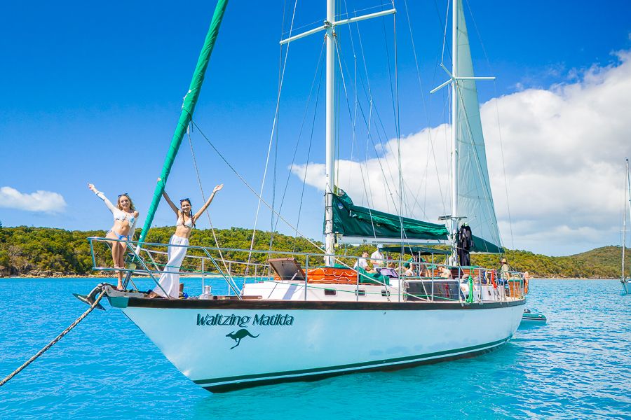 two women standing at the bow of a sailing boat