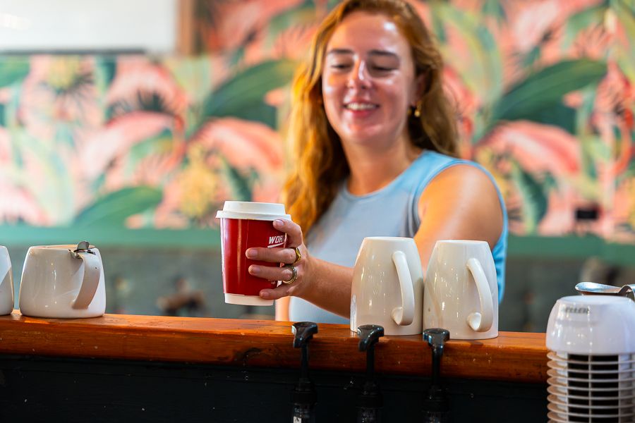 Sidewalk Cafe, Airlie Beach A woman in a blue top grabbing a takeaway coffee from Sidewalk Cafe