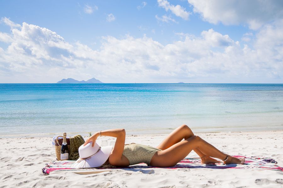 girl lounging on whitehaven beach whitsundays