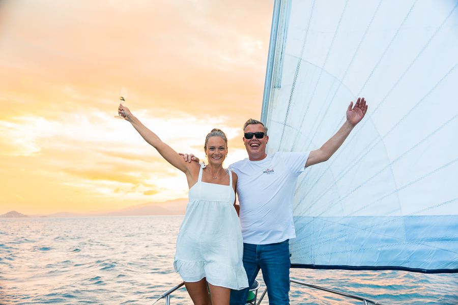 couple posing on a sunset sailboat whitsundays