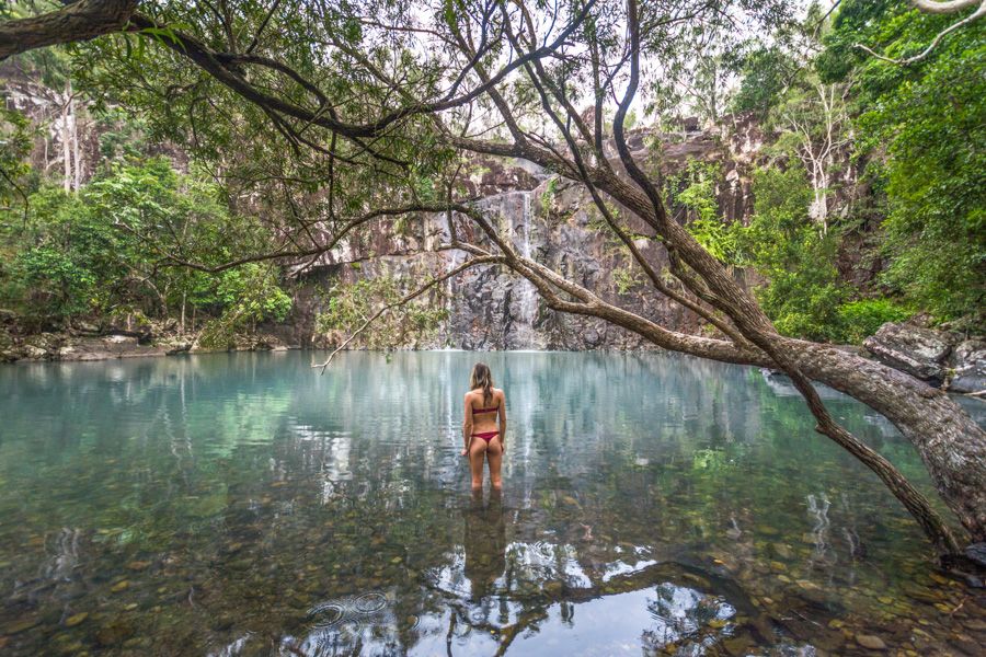 Woman going for a swim at Cedar Creek Falls, Queensland.