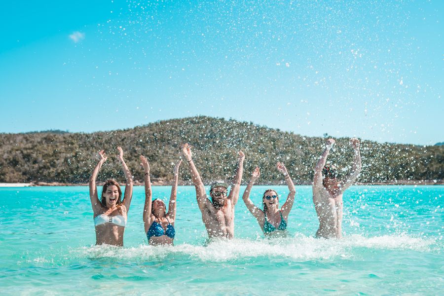 Group of people splashing in the ocean, Whitehaven Beach