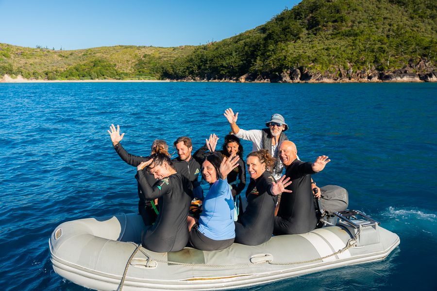 group of travellers on a tender wearing stinger suits