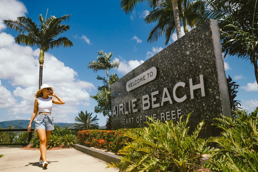 Women walking in front of the Airlie Beach entrance sign