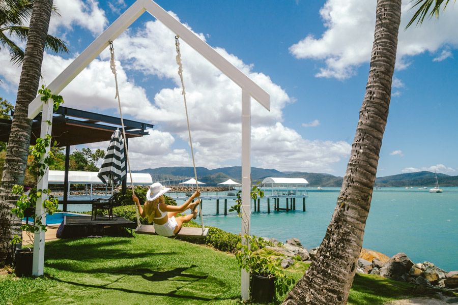 Women on a swing at Airlie Beach outlooking the Coral Sea Marina