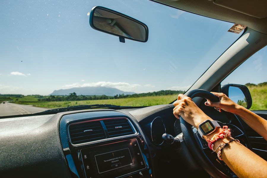 Hands on steering wheel, driving through Cairns