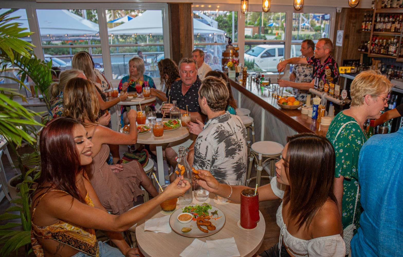 A group of people sitting at tables in a restaurant eating seafood