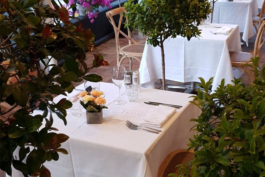 White table with cutlery set on it in an Italian restaurant