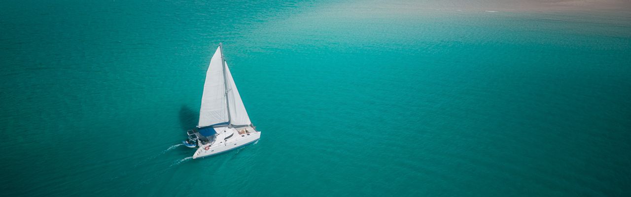 Whitsunday Blue A drone shot of a sailing catamaran