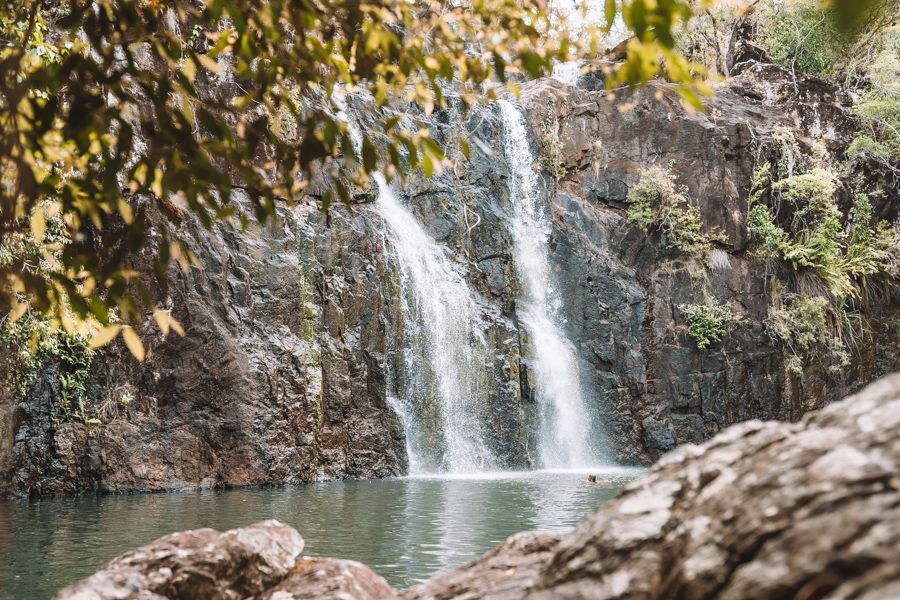 Waterfall surrounded by greenery and rocks and water