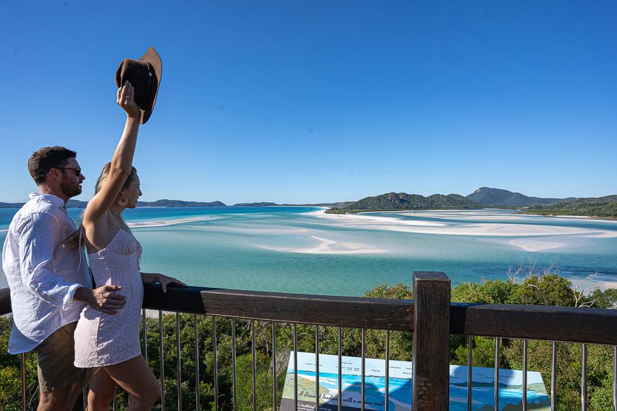 A couple standing at a lookout overlooking islands