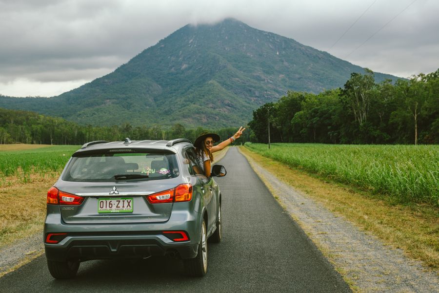 Person making a peace sign, Jucy Car Rental travelling through Cairns