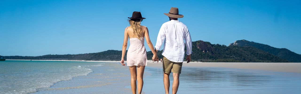 Couple walking along Whitehaven Beach