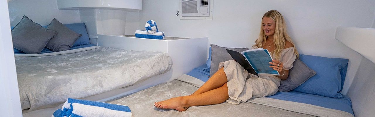 Powerplay forward private or shared quad cabin, with women lounging on bed