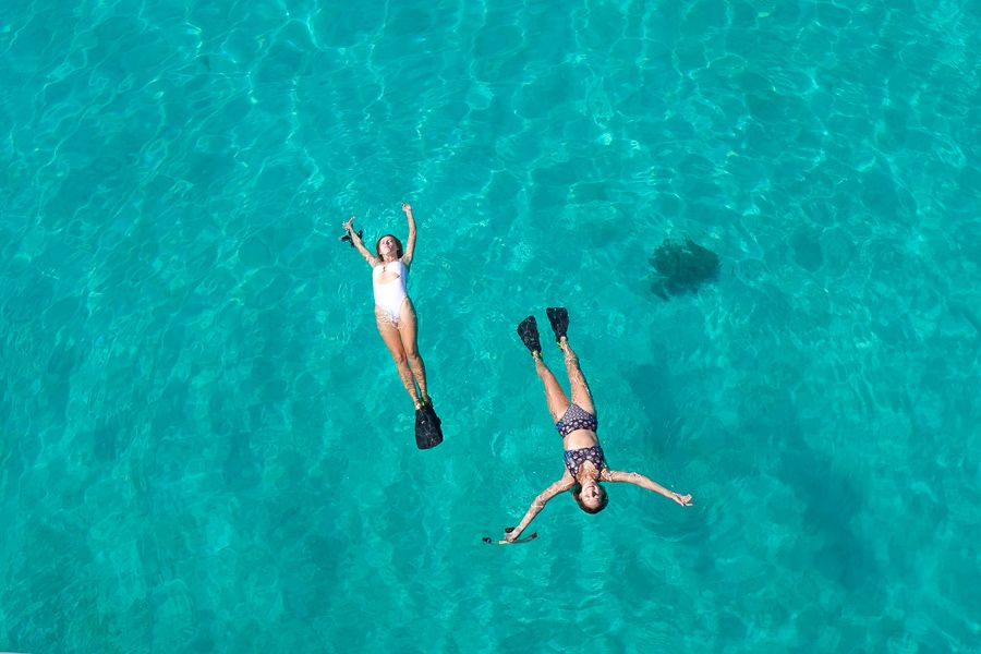 girls floating in blue water near the great barrier reef