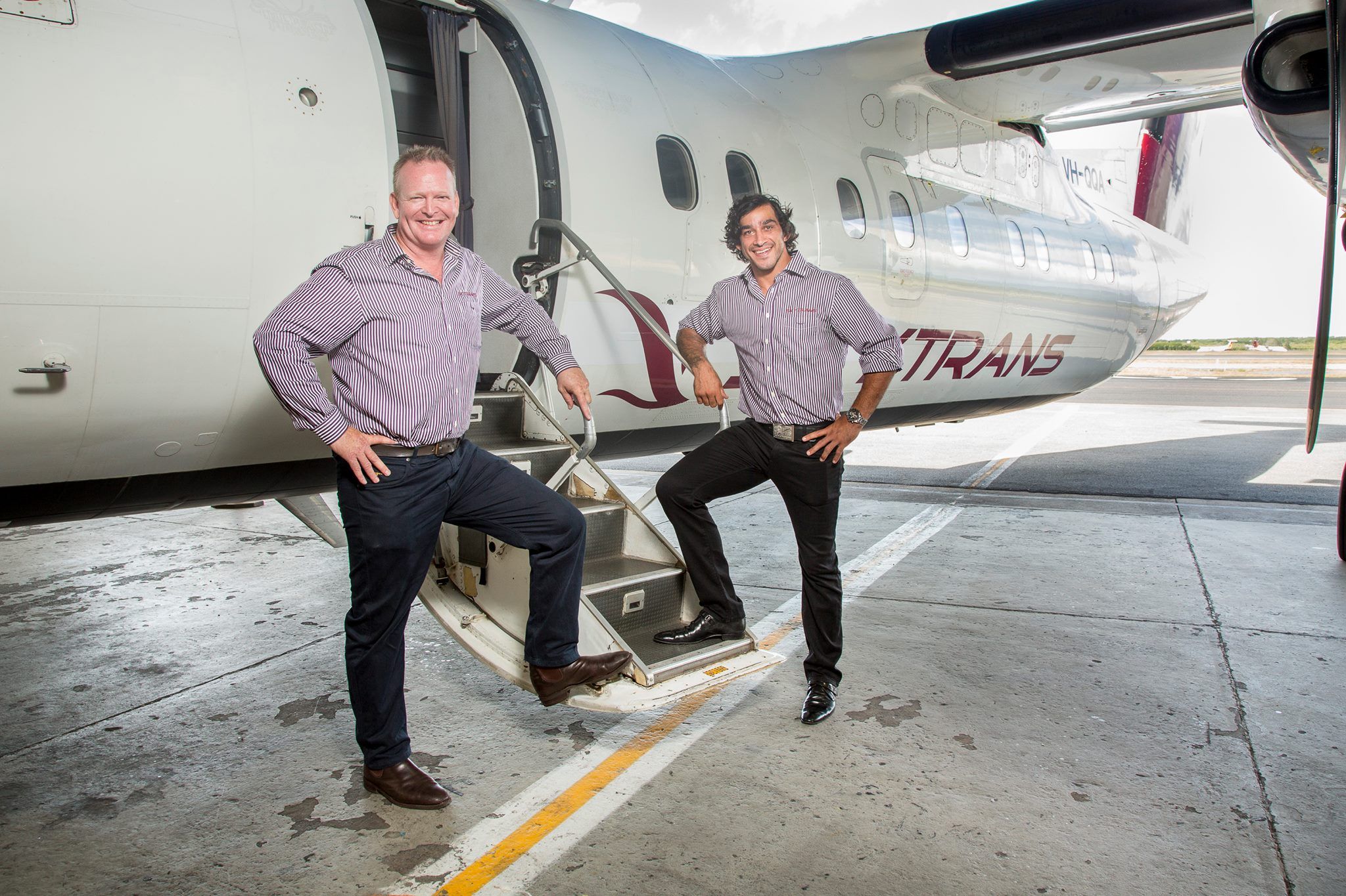 Two men standing in front of a plane called 'skytrans'