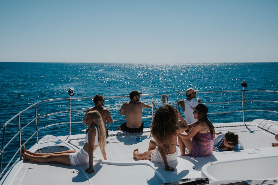 Group of people sitting aboard Powerplay catamaran's front decks in the Whitsundays