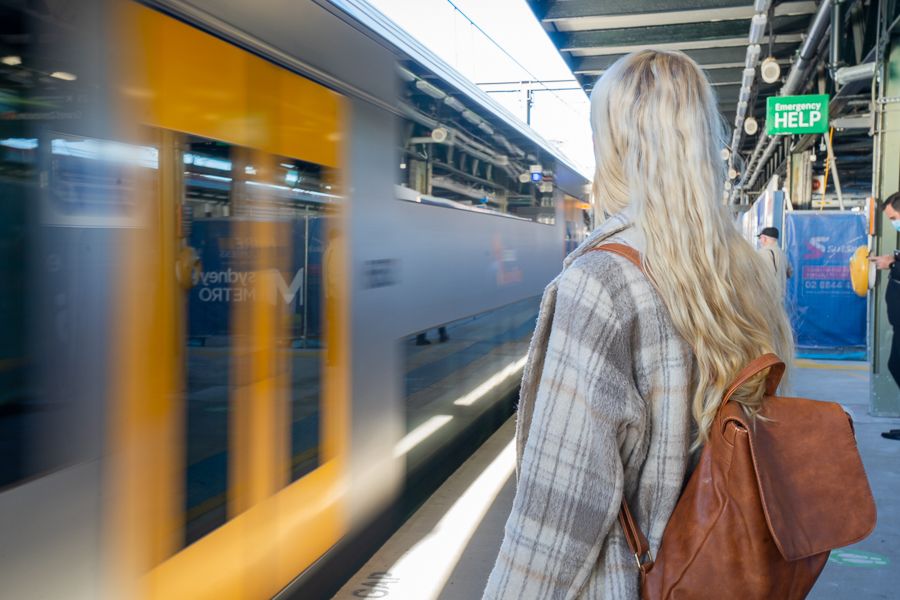 Person wearing a backpack about to board a train 