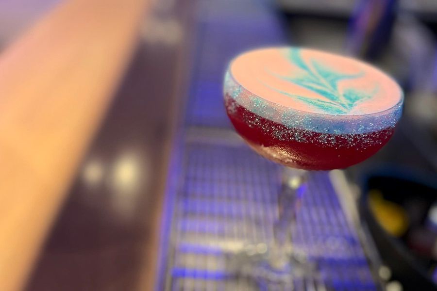 A cocktail sitting on a bar bench