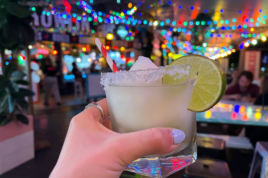 A photo of a green cocktail in a short glass with a lime on the side