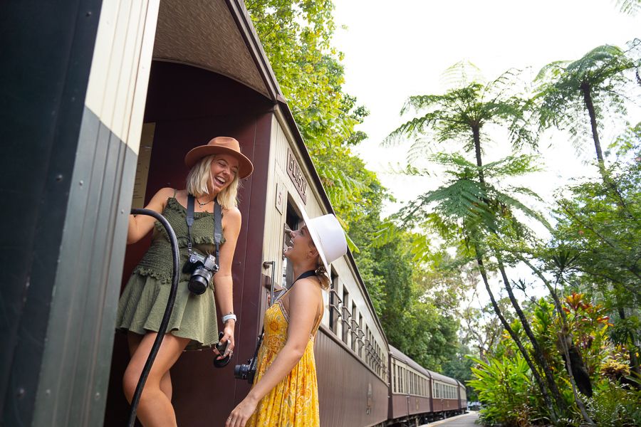 Two girls hanging off the side of a train