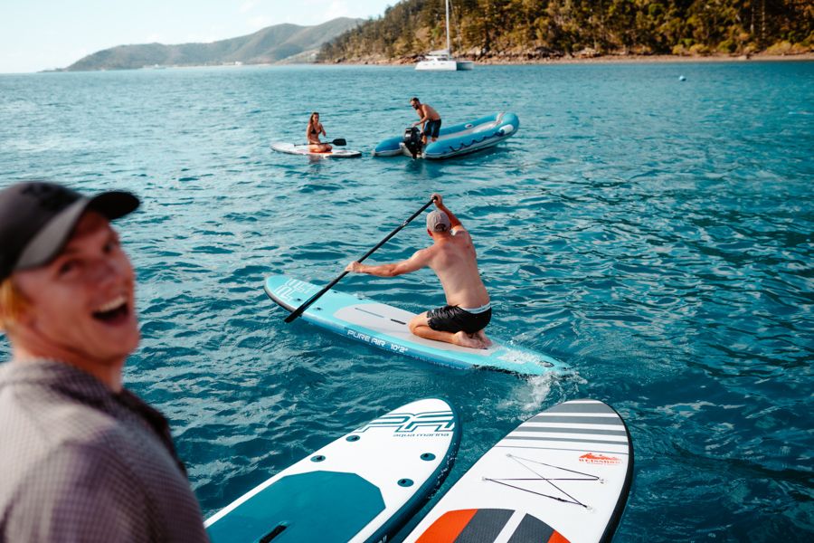 Group of people laughing on paddleboards in the Whitsunday Islands