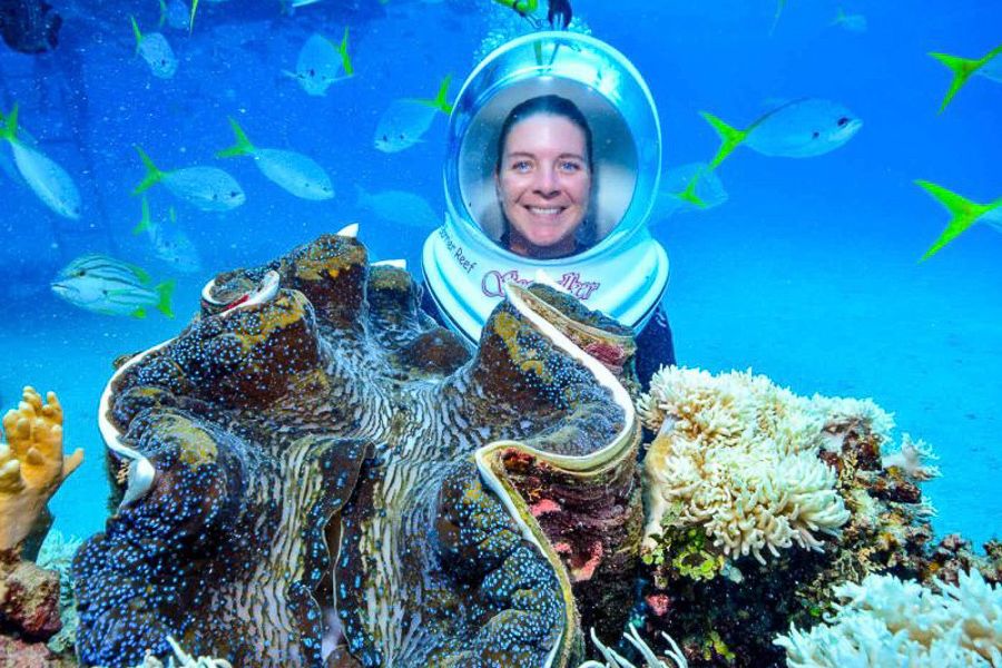 A woman wearing a diving helmet underwater