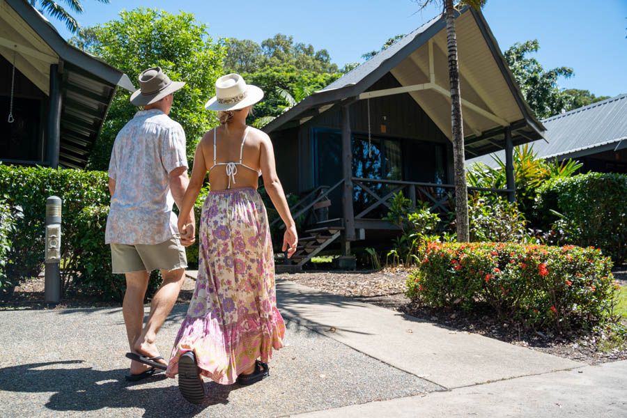 Couple hand in hand walking into a Hamilton Island Palm Bungalow accomodation 