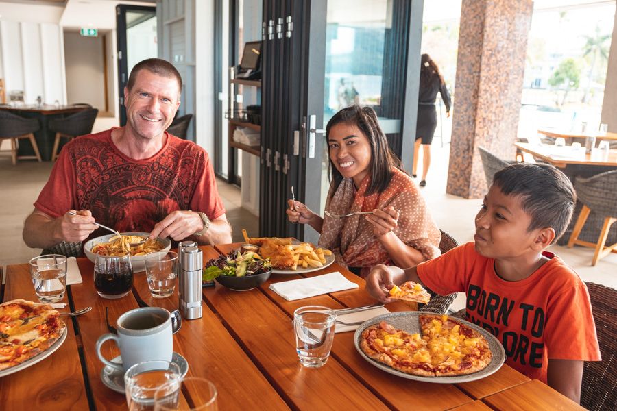 Family at a restaurant table eating different dishes 