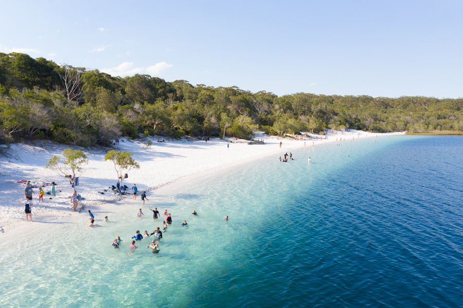 Group of people swimming in Lake McKenzie from afar