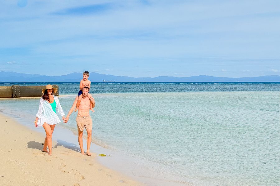 family walking on green island near cairns